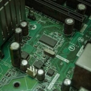 Detailed view of electronic components on a green circuit board surface.